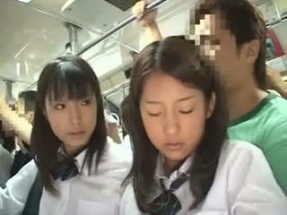 Two schoolgirls betast in een bus