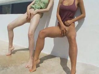 Two girlfriends peeing on a terrace