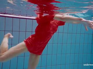 Rosso lungo abito e grande tette floating in il piscina